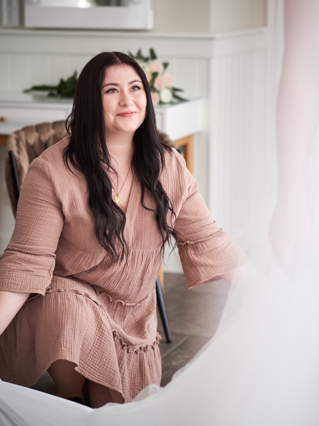 Alexa Grimm sitzt lächelnd neben Brautschleier und Blumendekoration
