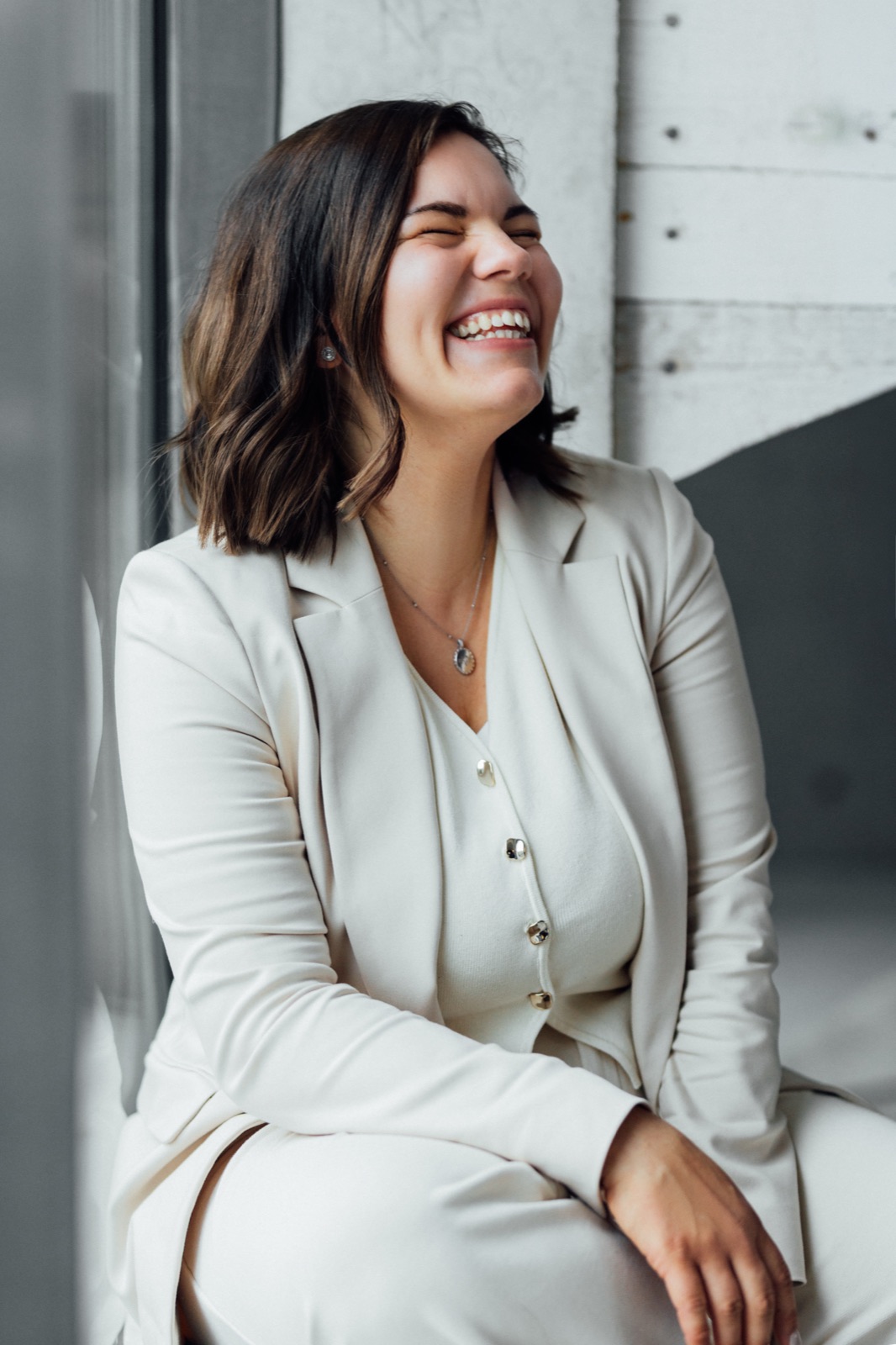 Fiona-Lisann lacht herzlich, Portrait im cremefarbenen Anzug